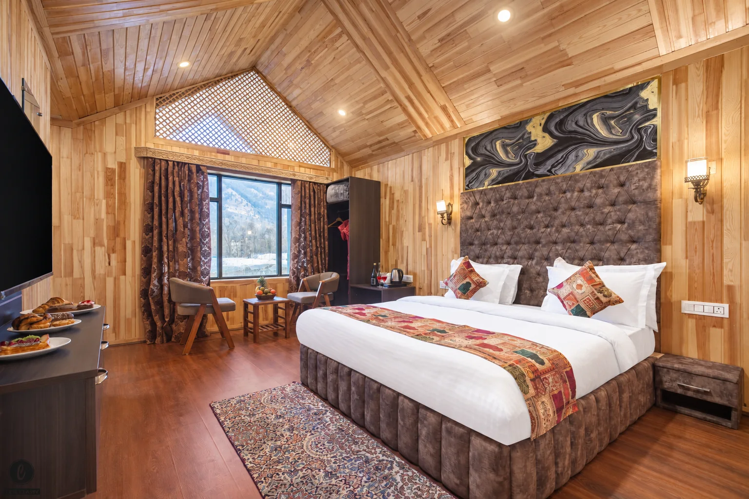 Timber-lined Deluxe room with an upholstered bed and seating beside the window