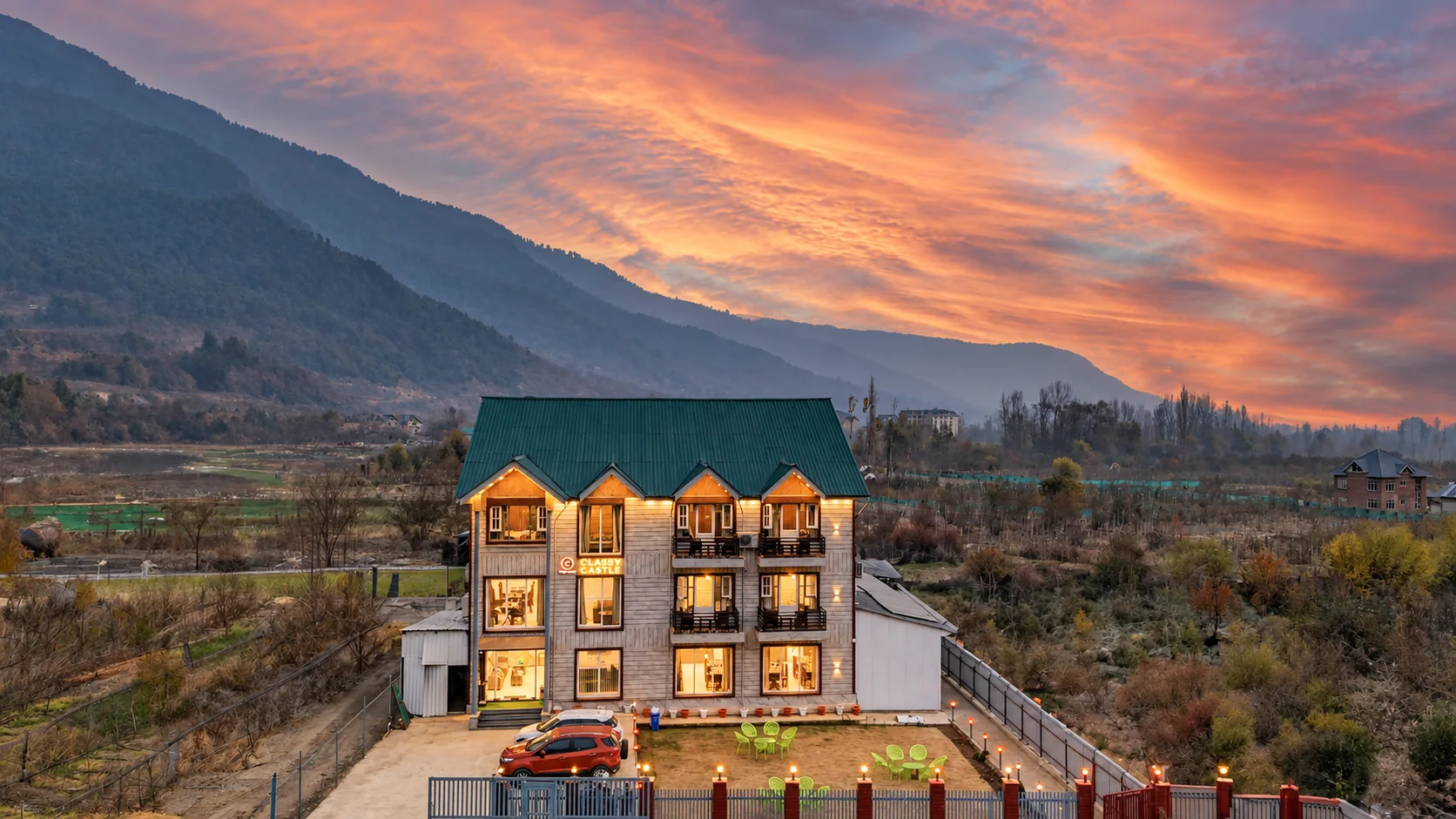 The Classy Castle by Nasmu Stays hotel facade at sunset, with its photographed driveway, side structures and surrounding valley
